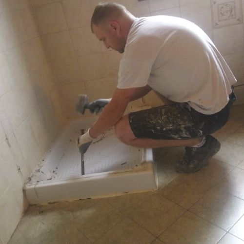 Gli operai rimuovono la vecchia doccia preservando le piastrelle circostanti